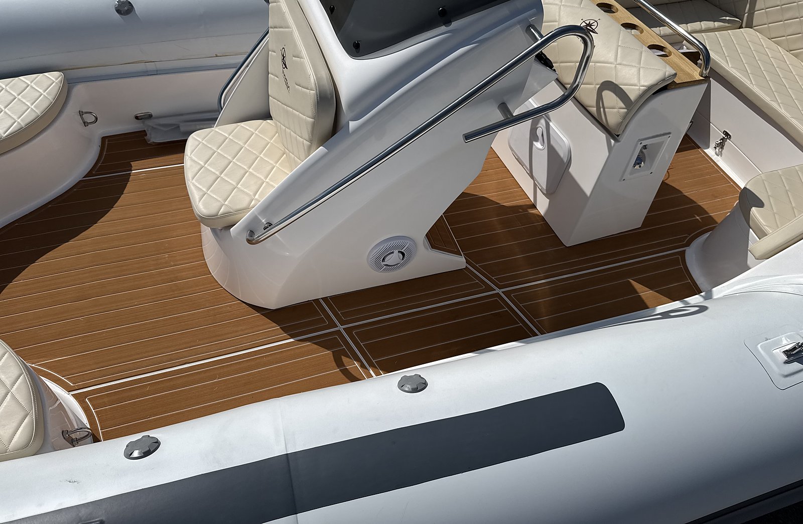 Side view of the white NAVY 7.60 console: cream seat, stainless grab rail and teak-effect decking