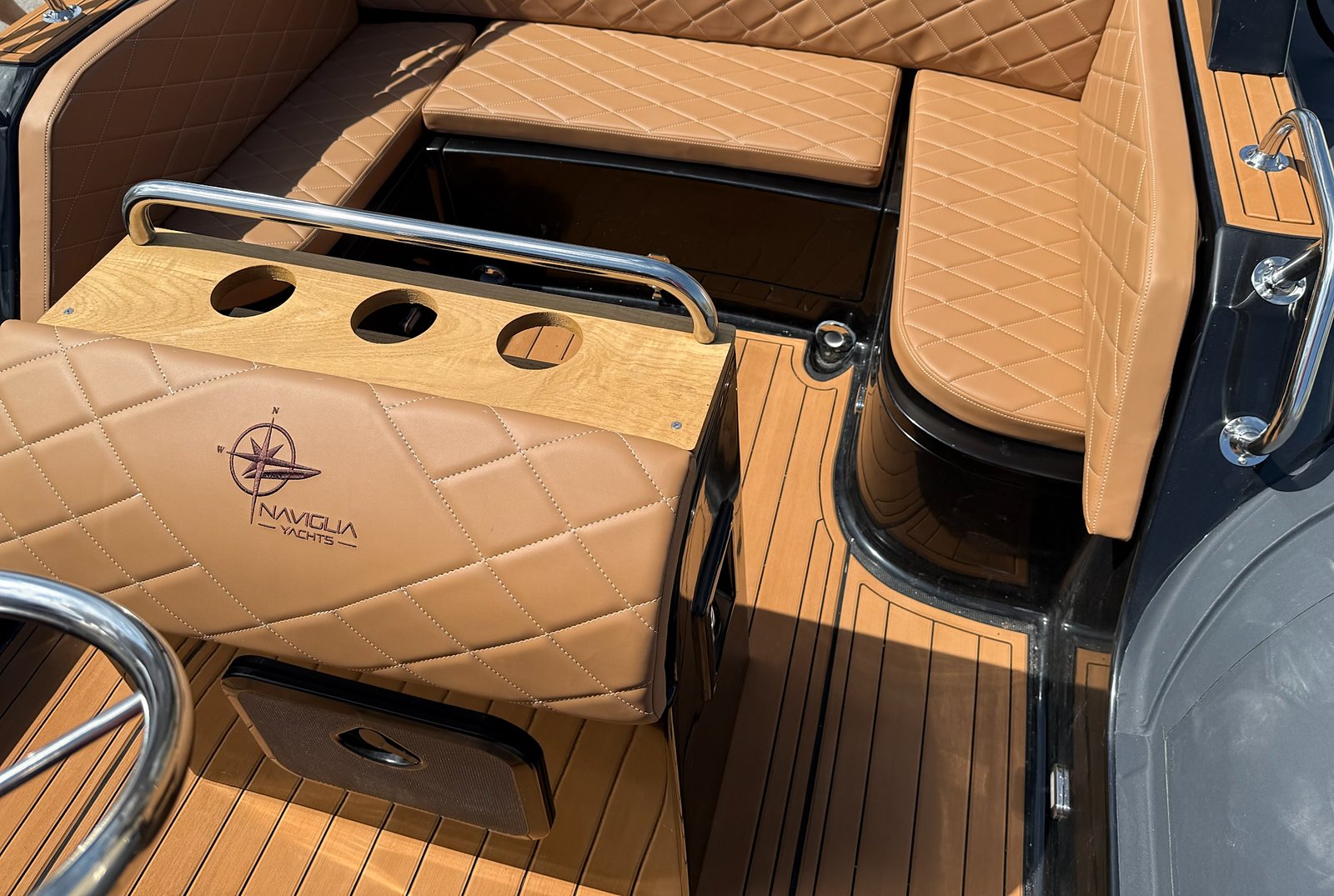 Aft dinette of the NAVY 7.60 with tan upholstery and Naviglia Yachts logo