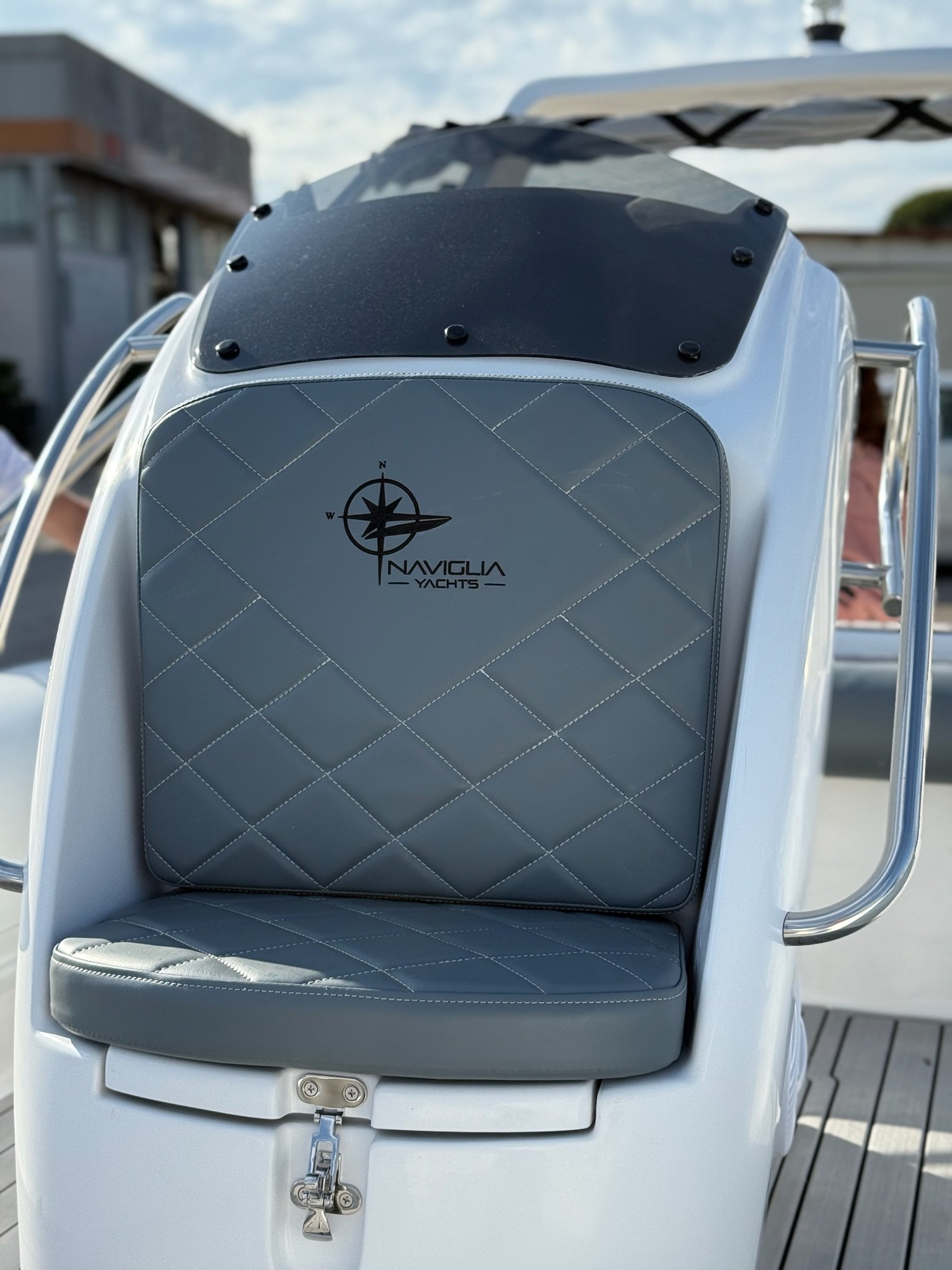 Grey quilted console seat with Naviglia Yachts logo on the white NAVY 6.00