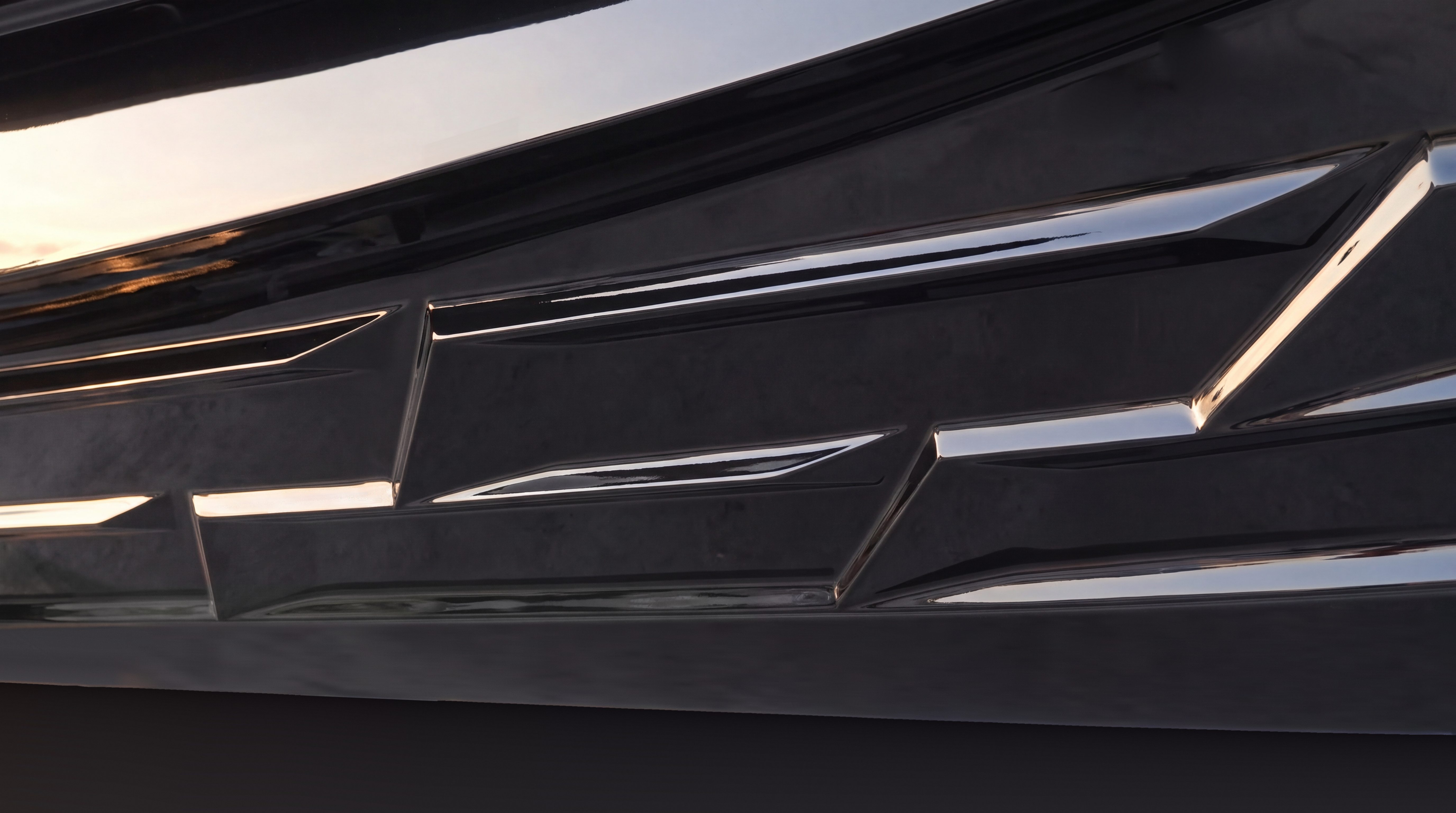 Naviglia vision from a photograph of the real hull: the gloss black bottom of the NAVY 9.50, a deep-V, double-step hull, seen up close from below, with sharp strakes that stop and start again, staggered