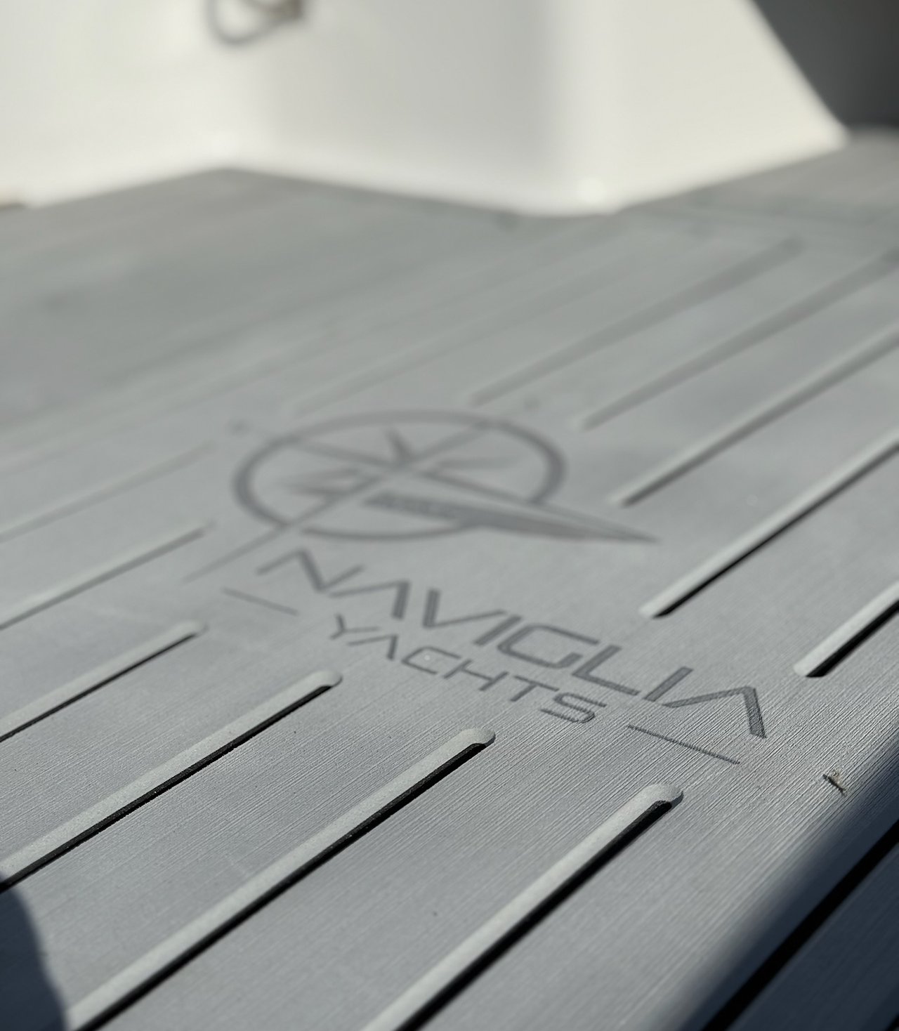 Logo Naviglia Yachts inciso nel pagliolo in EVA grigio del NAVY 6.00, in prospettiva