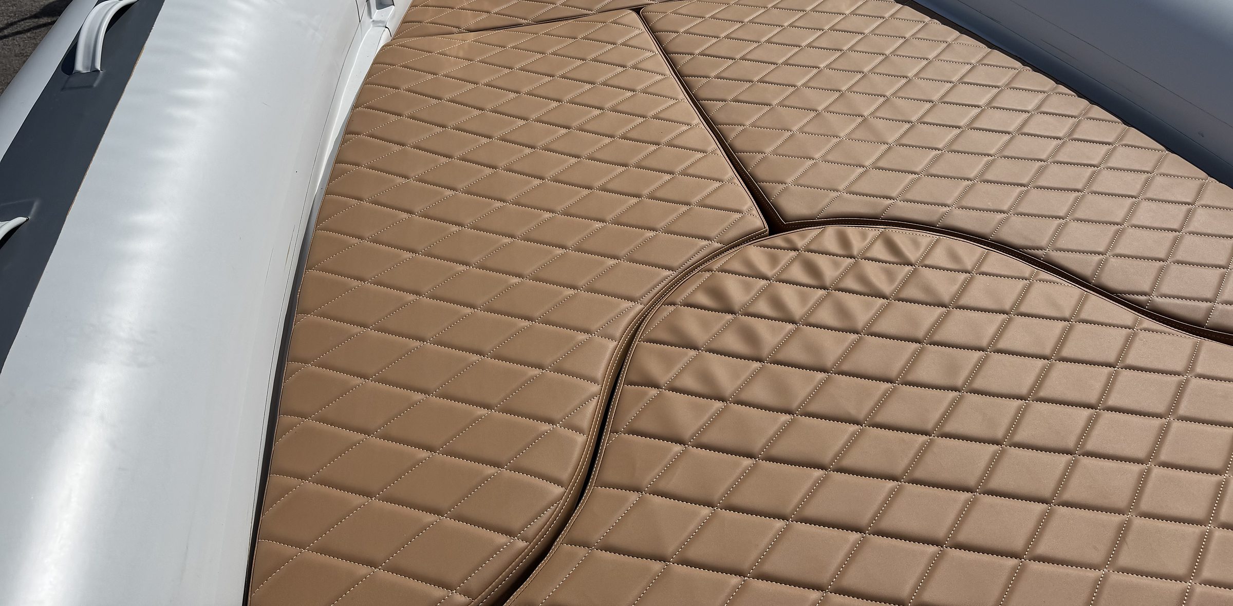Diamond-quilted tobacco bow sundeck beside the white tube of the NAVY 7.60