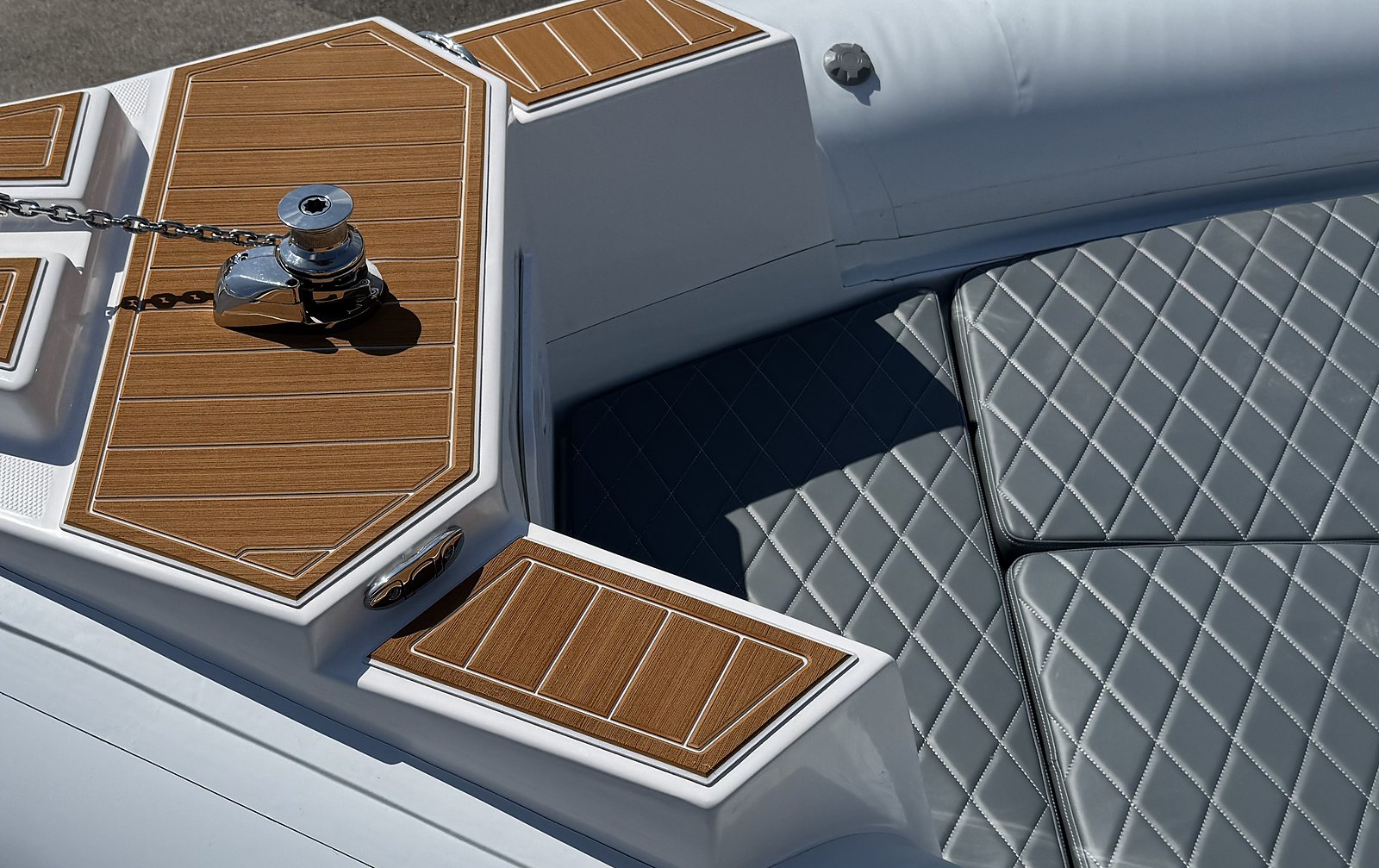Prua del NAVY 7.60 bianco: gavone effetto teak, verricello inox, cuscini grigi trapuntati