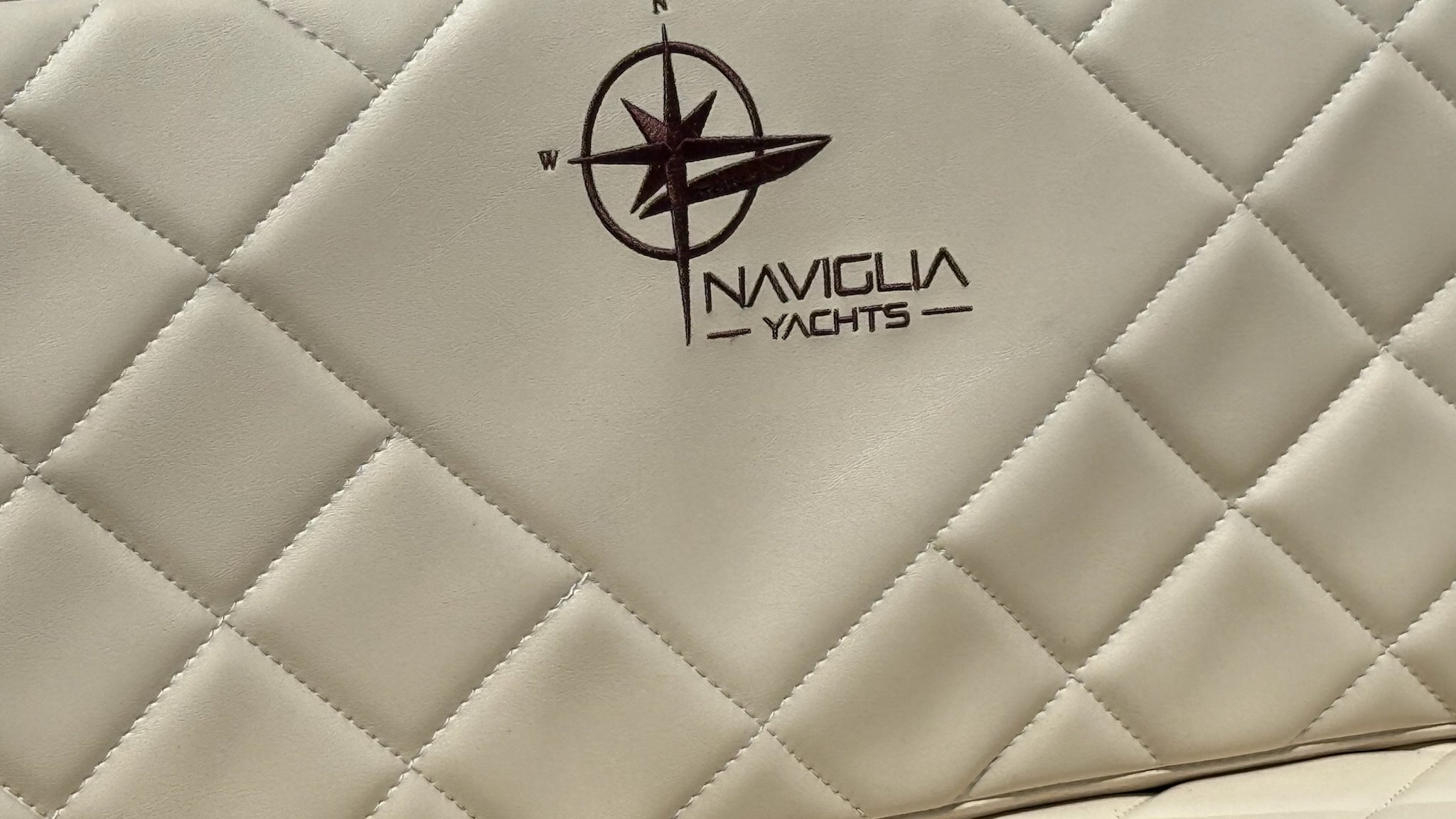 Logo Naviglia Yachts ricamato bordeaux su similpelle crema trapuntata a rombi