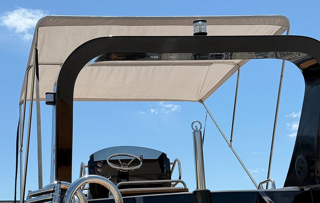 Roll-bar nero lucido del NAVY 7.60 con tendalino beige aperto e luce di fonda