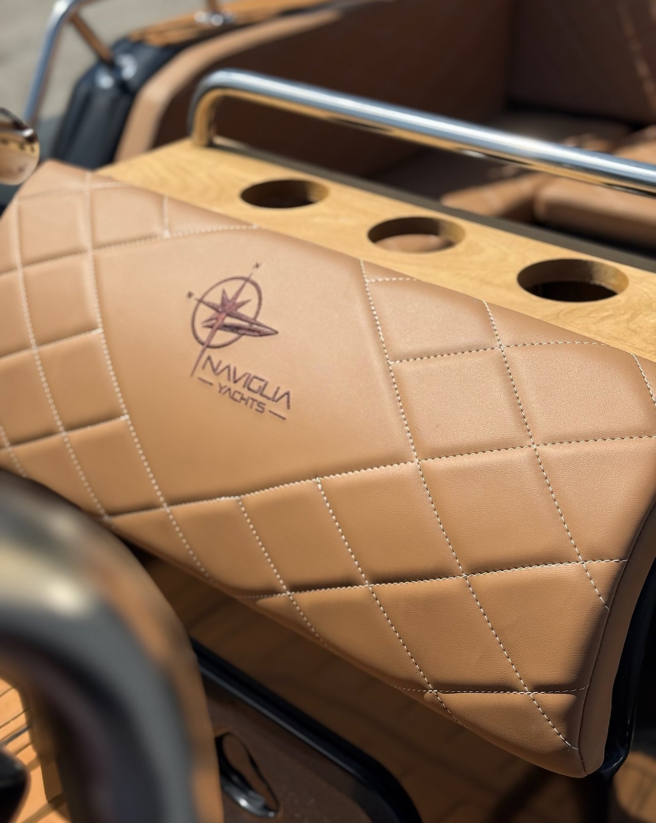 Tan leatherette bolster with embroidered logo and wooden cup-holder top, vertical