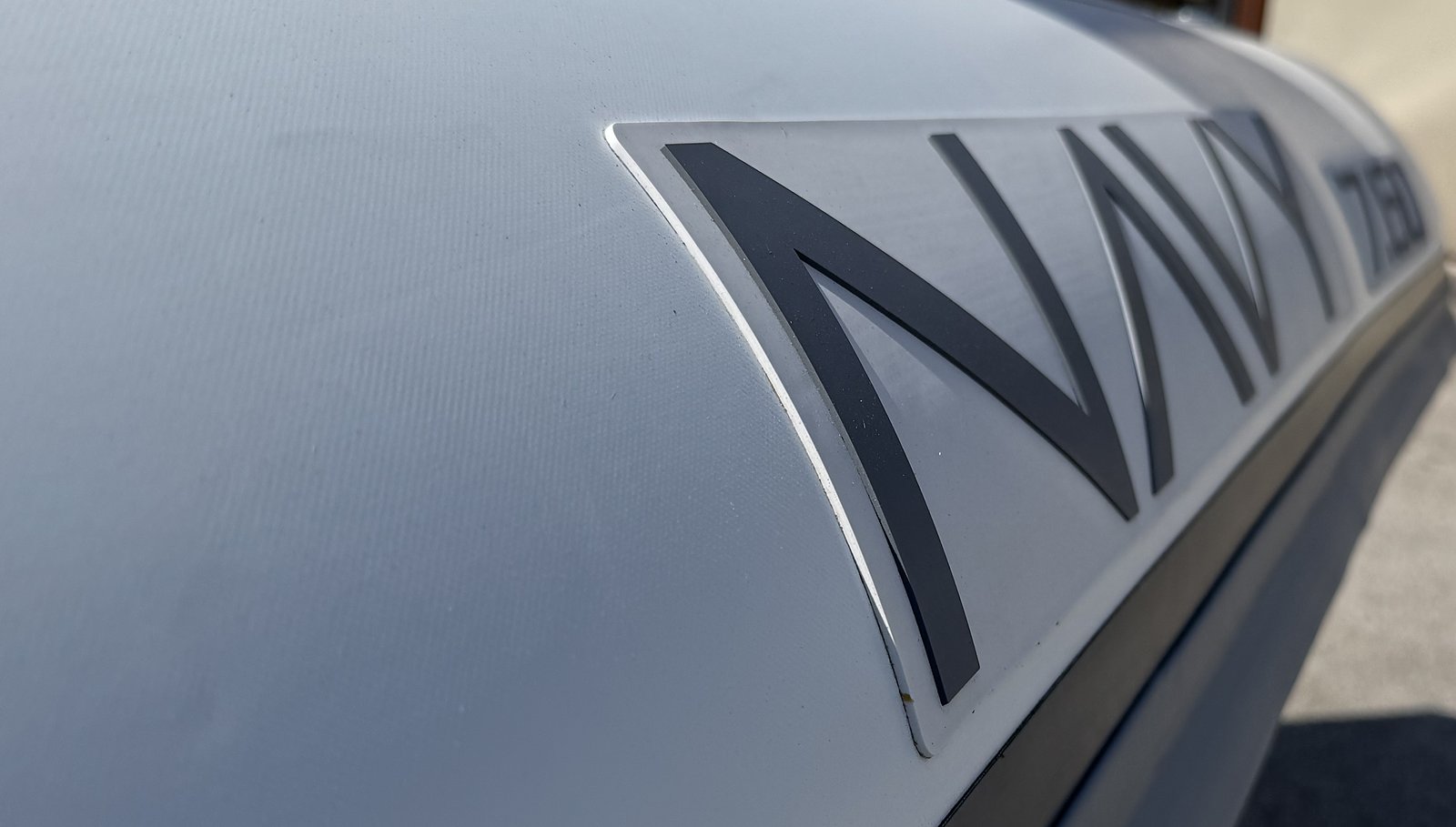 Primo piano della scritta NAVY grigio scuro in rilievo sul tubolare bianco del 7.60