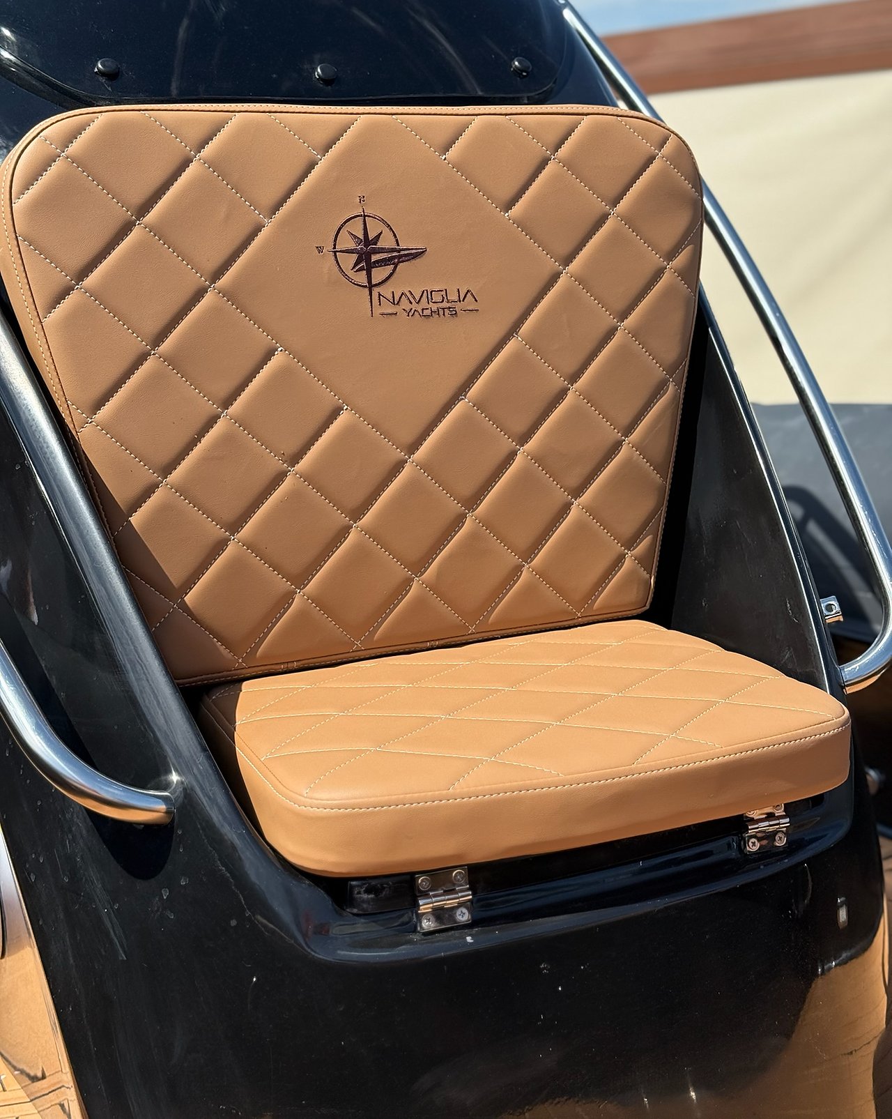 Tan console seat with embroidered logo on the gloss black console, NAVY 7.60