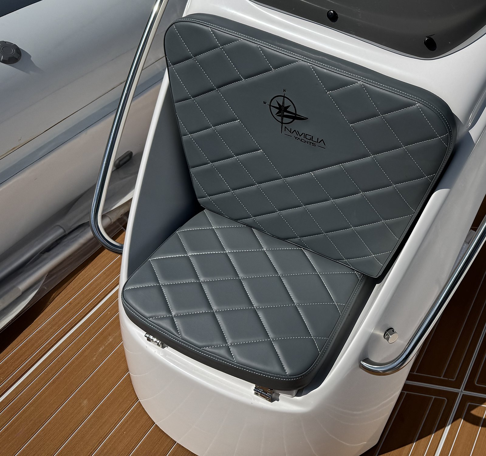 Grey quilted console seat with logo on the white NAVY 7.60, teak-effect deck