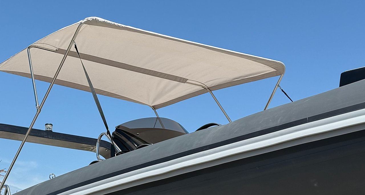 Tendalino beige aperto sul roll-bar del NAVY 7.60 antracite, dal basso contro il cielo