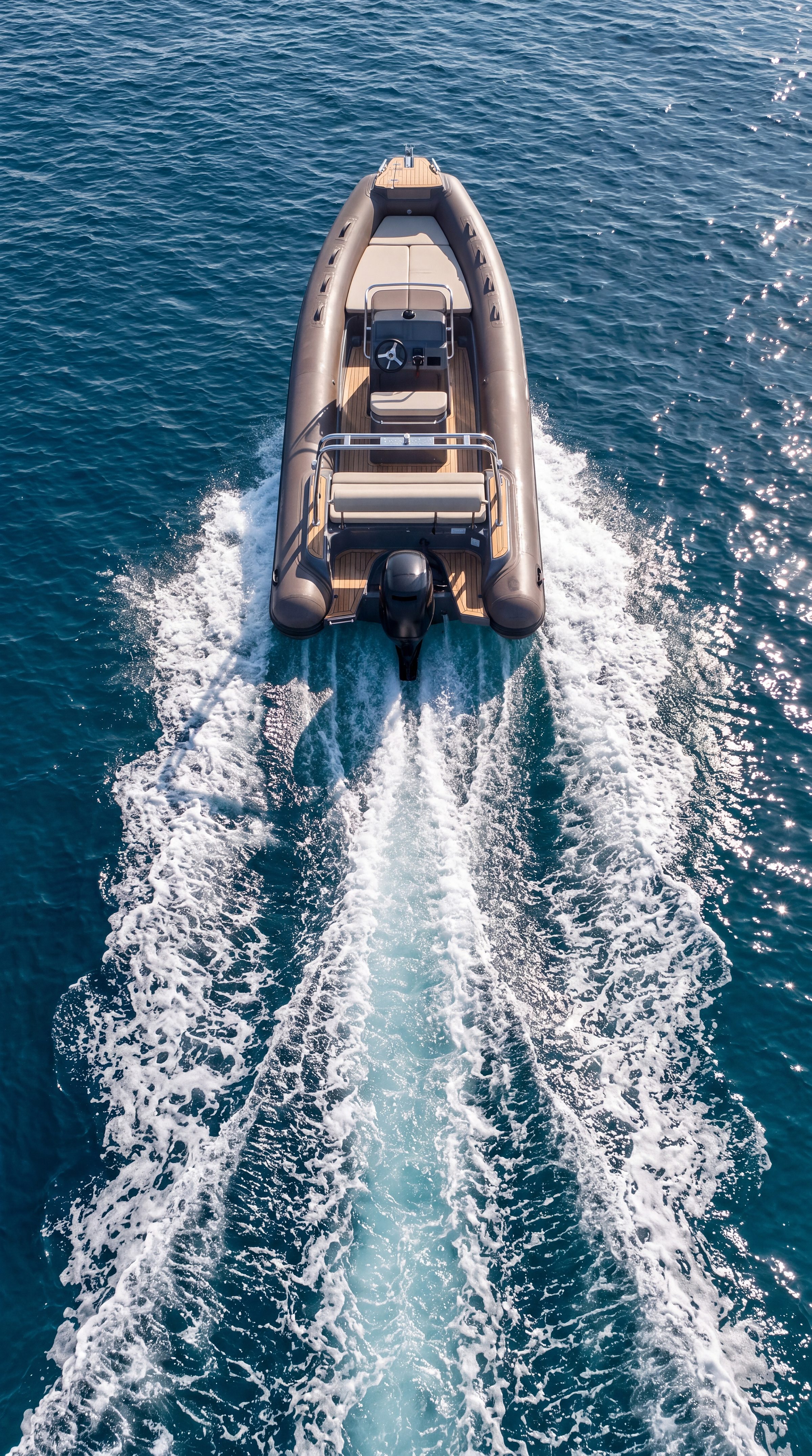 Naviglia vision: the NAVY 5.50 planing, seen from above and astern, with its long white wake on the blue sea