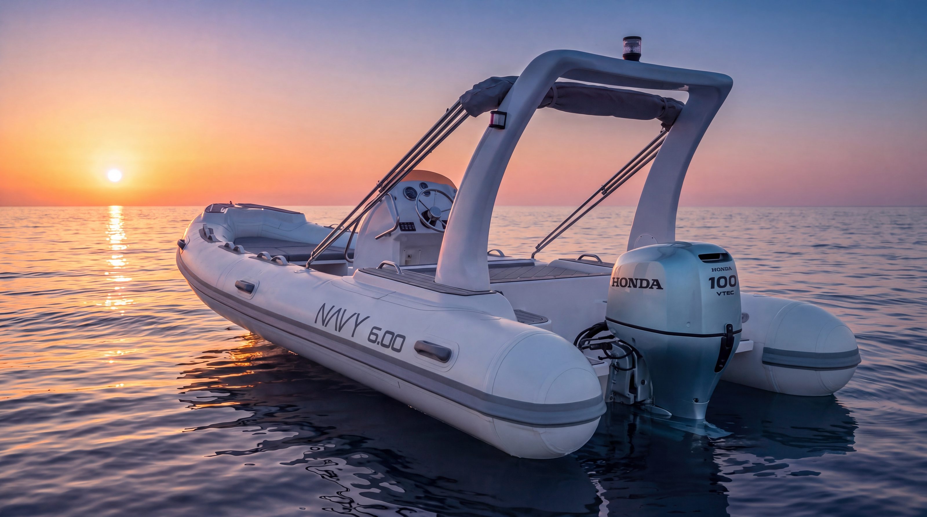 Naviglia vision: the white NAVY 6.00 at sunset, stern three-quarter view, with round tube ends, the grey rubbing strake wrapping around them, a silver Honda BF100 and the NAVY 6.00 lettering on the tube