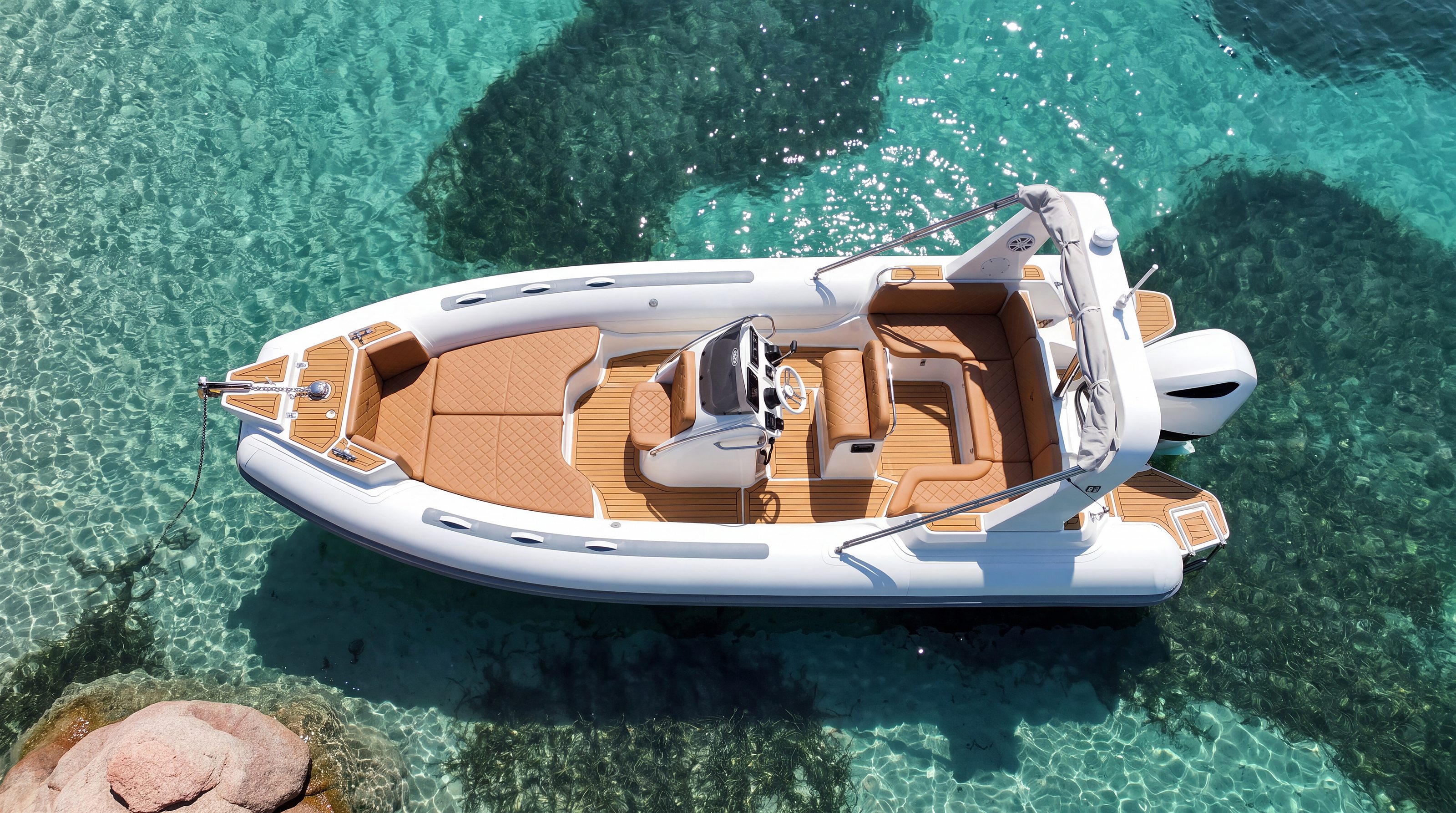 Naviglia vision: the white NAVY 7.60 at anchor seen from above on turquoise water, with tan upholstery and the outboard at the stern