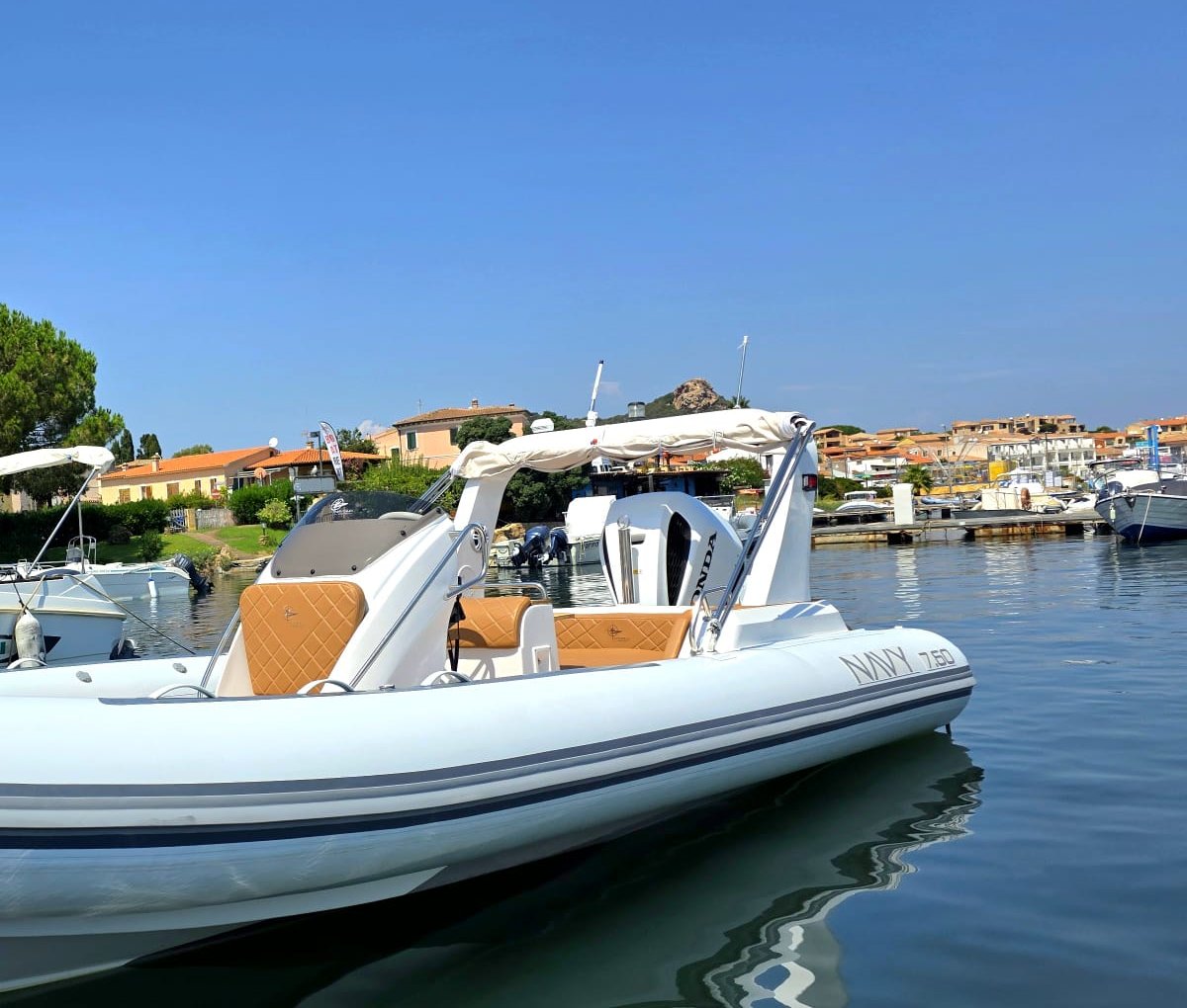 NAVY 7.60 ormeggiato in porto: sedute cuoio trapuntate, roll-bar con tendalino e scritta sul tubolare