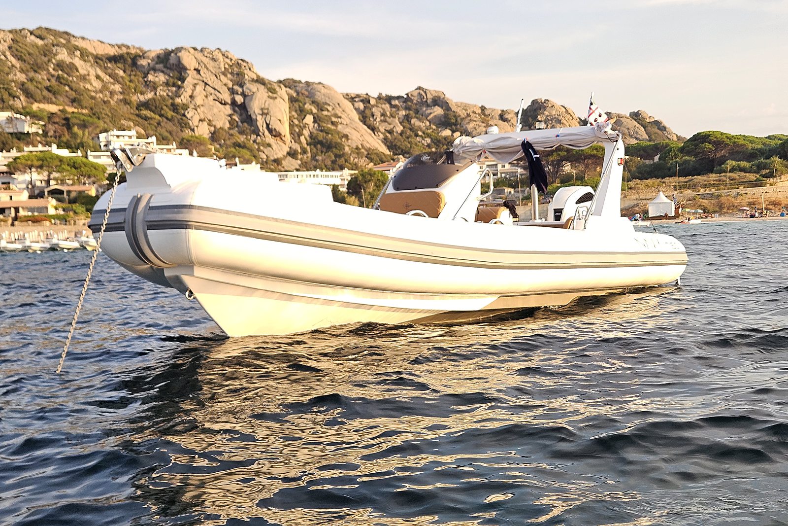 NAVY 7.60 bow in golden light, anchor chain in the water, console with tan upholstery