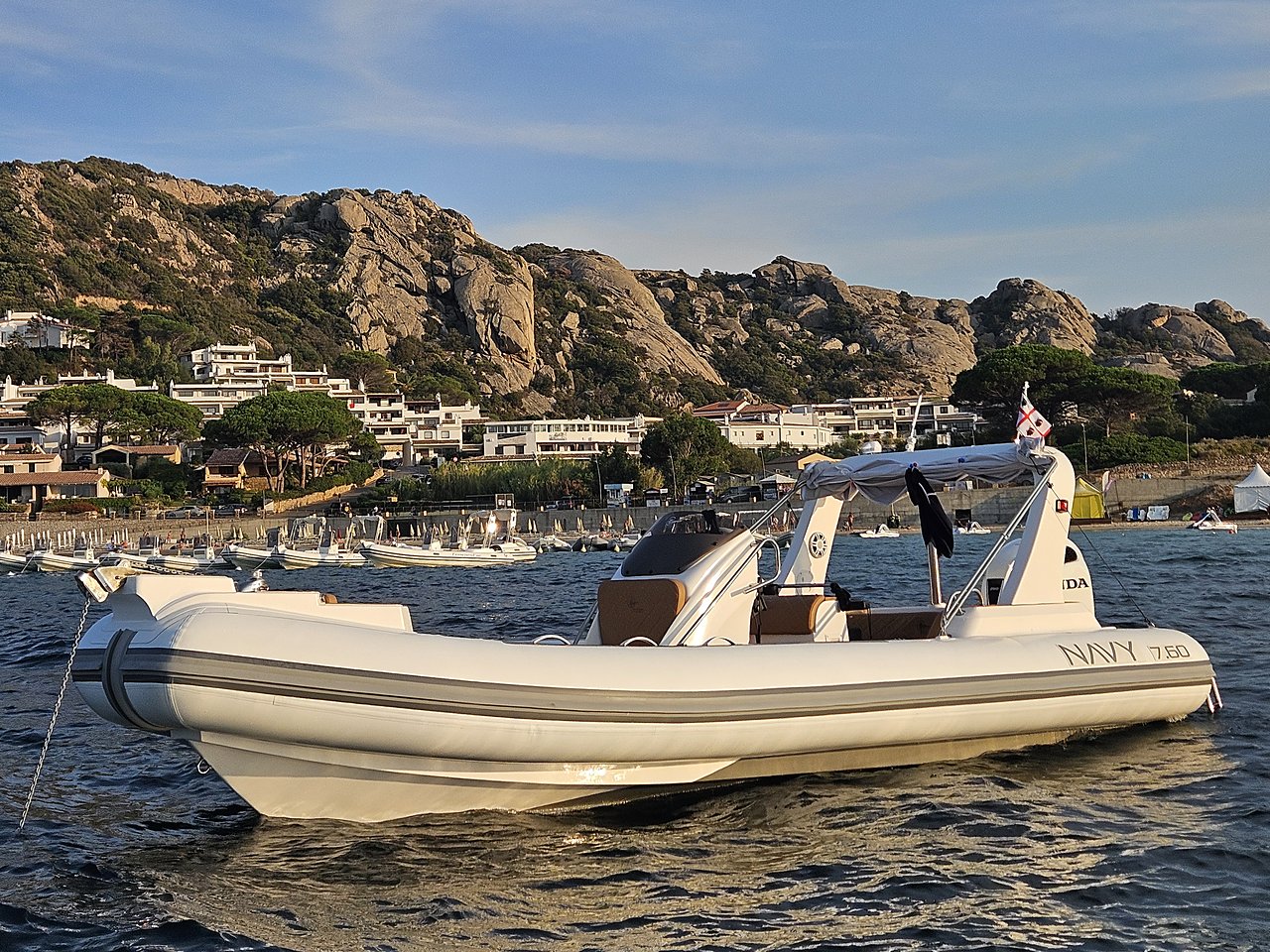 NAVY 7.60 bianco all'ancora di tre quarti da prua, scafo intero e costa di granito