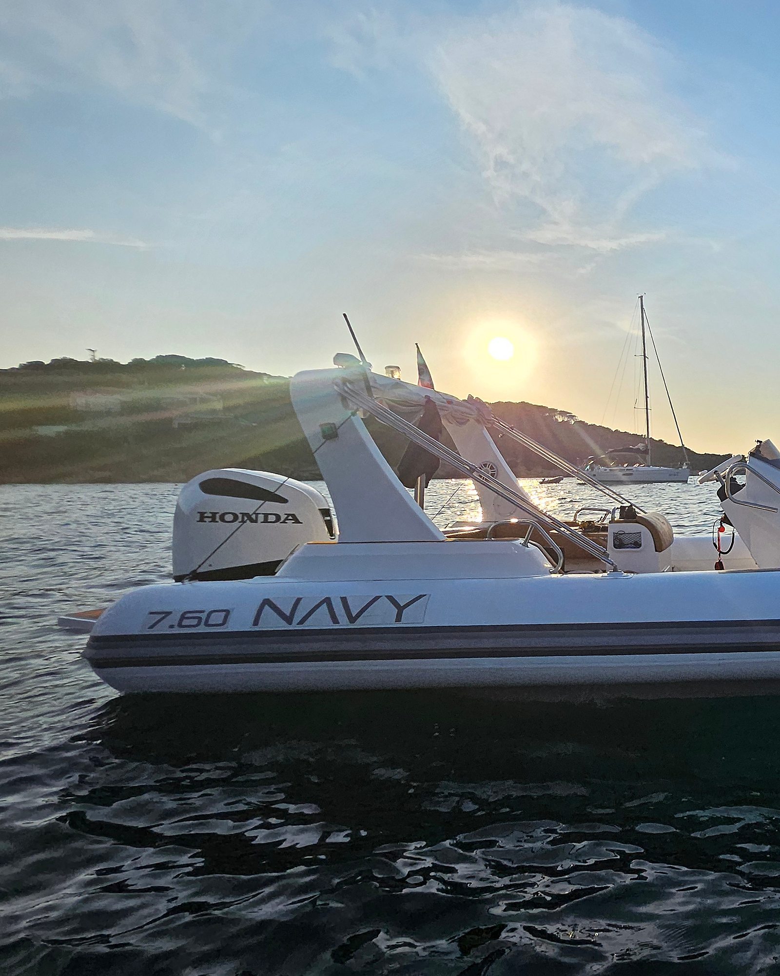 Backlit stern of the NAVY 7.60 with the sun behind the roll bar and Honda outboard