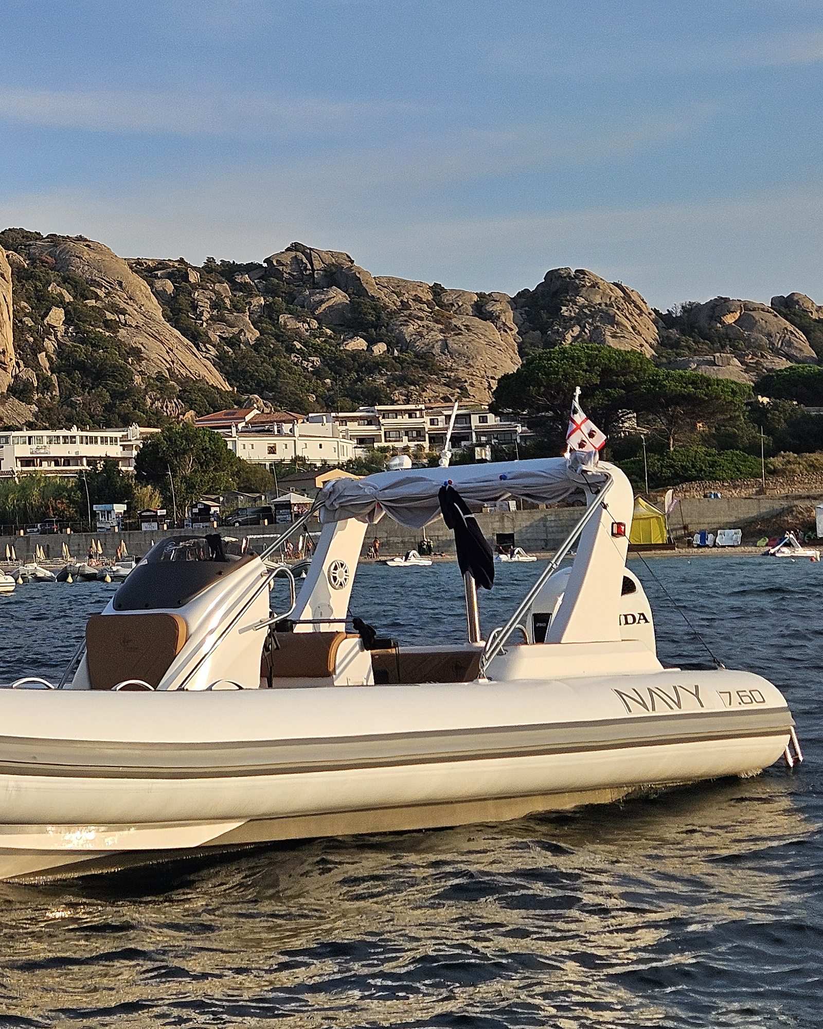 Metà poppiera del NAVY 7.60 con roll-bar e scritta, case bianche e granito sullo sfondo
