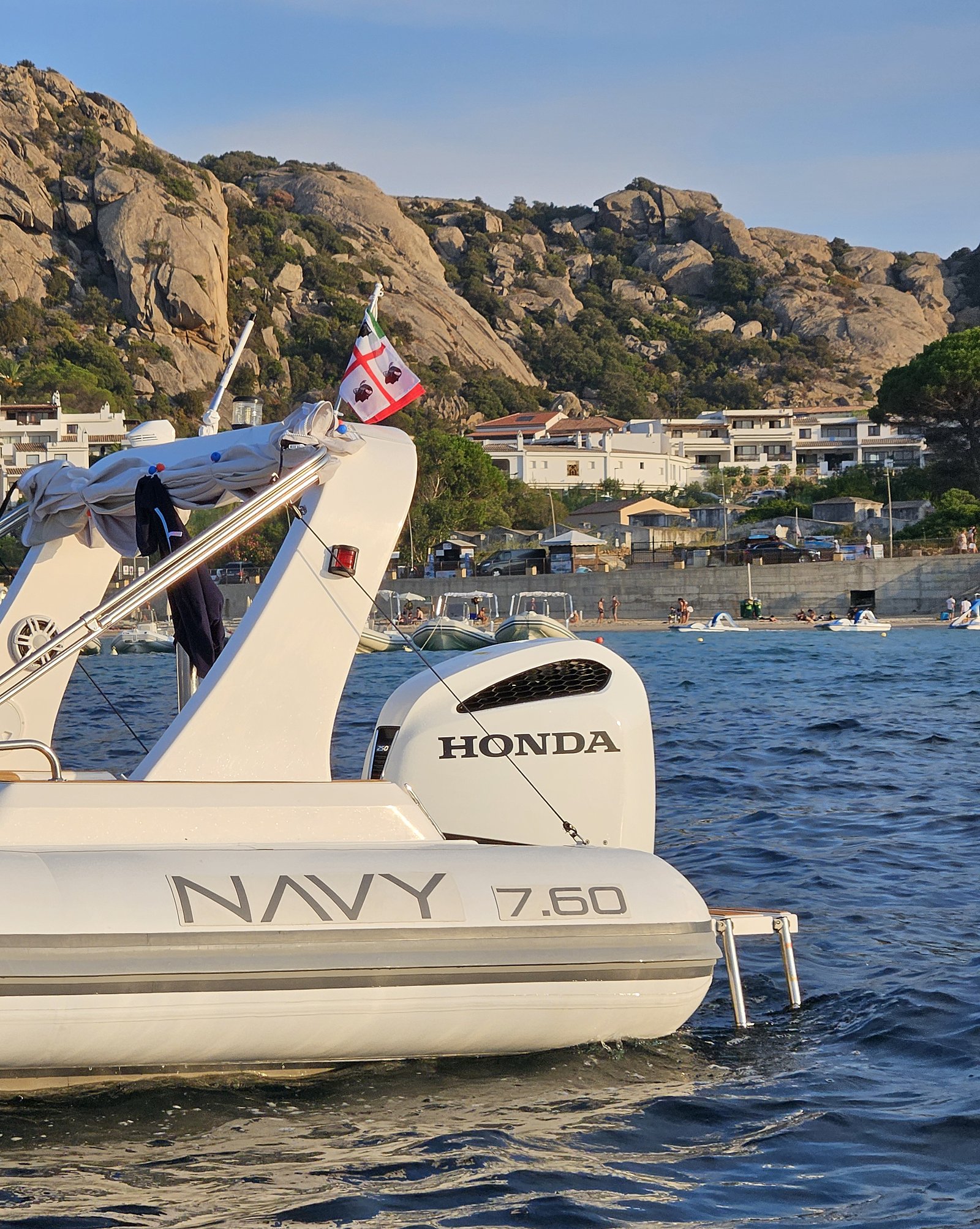 NAVY 7.60 roll bar with flag, Honda outboard and NAVY 7.60 lettering, granite rocks behind