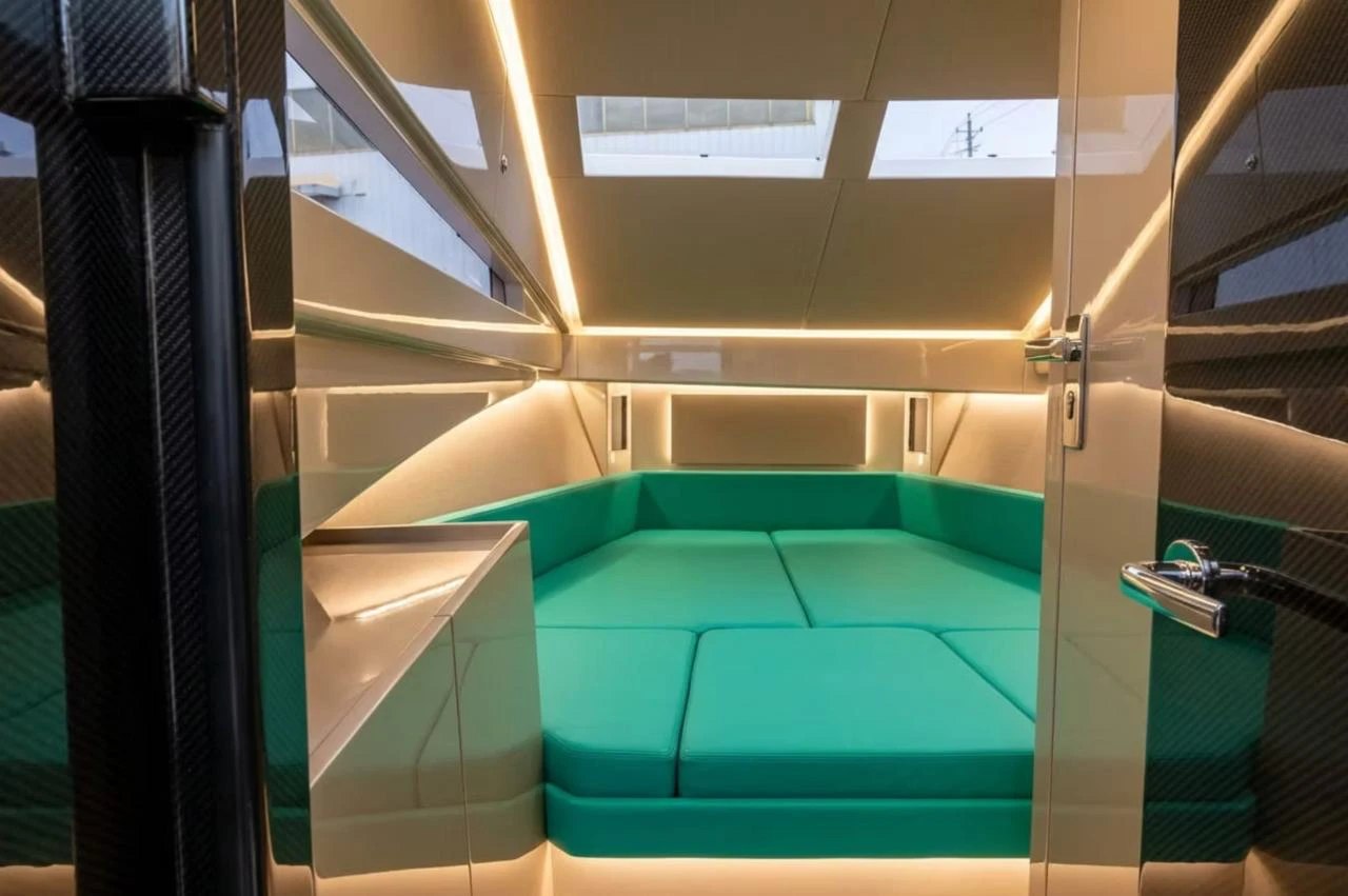 Naviglia vision: the forward cabin of the new NAVY 9.50 Cabin seen from the door, with the turquoise V-berth in panels, warm lighting and two overhead hatches