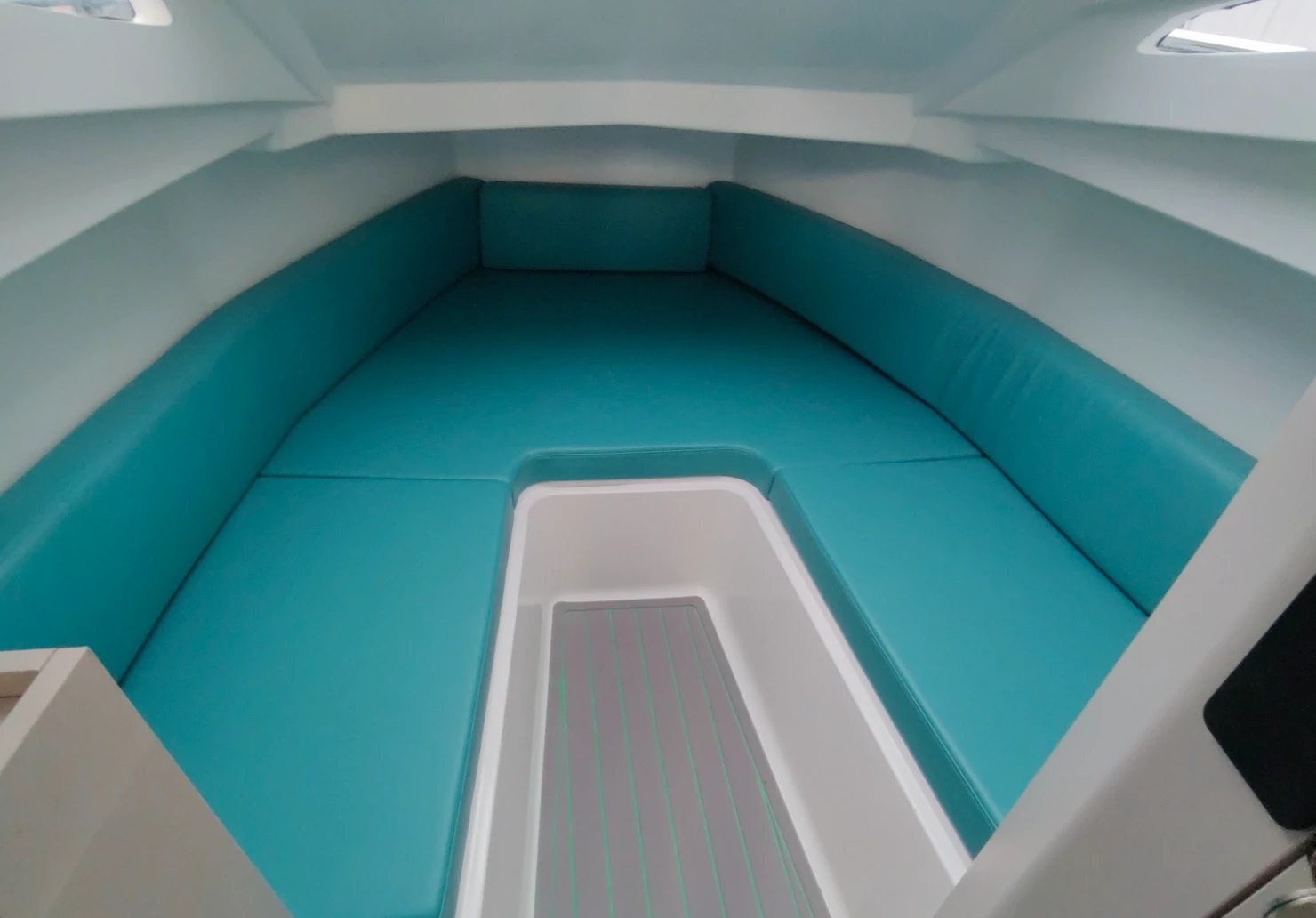 Real photograph, at the yard: the V-berth in the forward cabin of the NAVY 9.50 Cabin, with turquoise faux-leather cushions