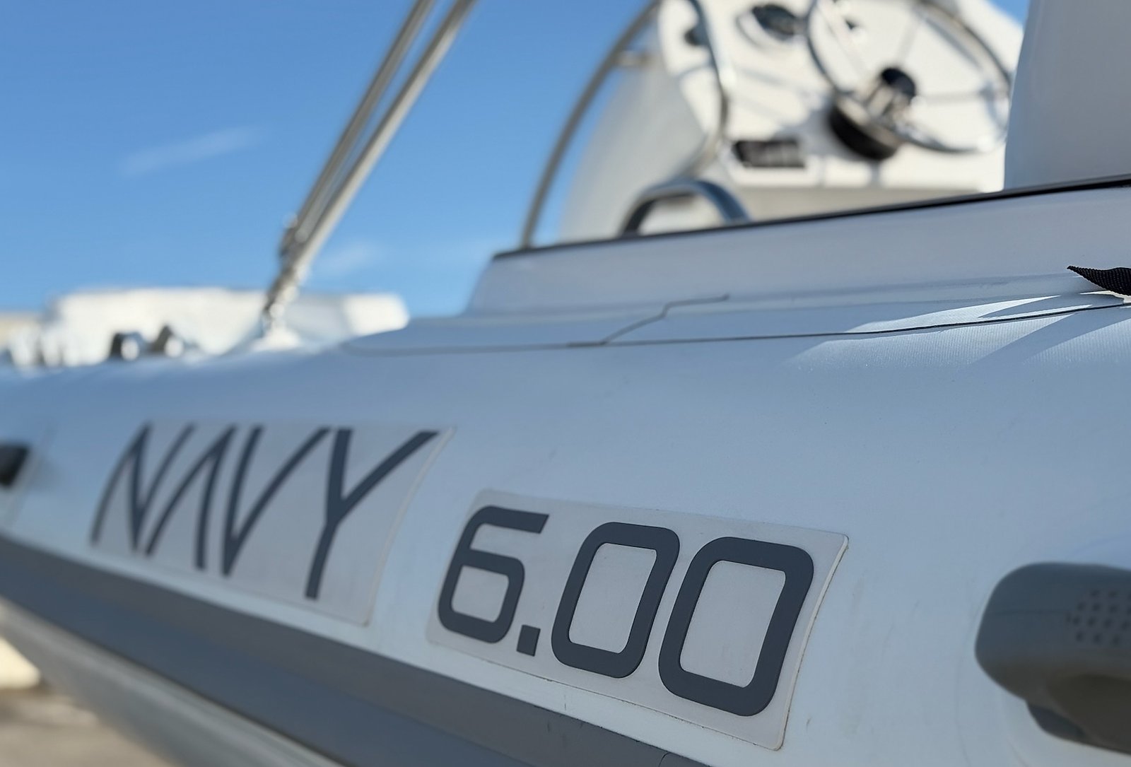 Dark grey NAVY 6.00 lettering on the white tube, blurred console and blue sky