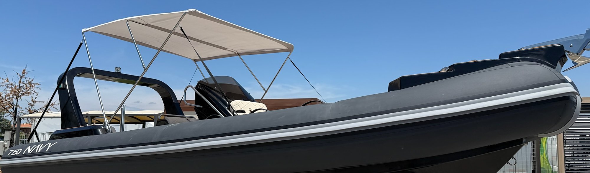 Profilo del NAVY 7.60 antracite con tendalino chiaro aperto e roll-bar nero contro il cielo